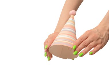 Beyaz arka planda izole edilmiş kadınların ellerinde renkli bir doğum günü şapkası.