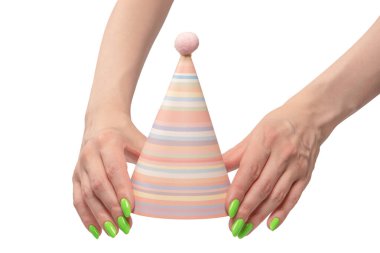 Beyaz arka planda izole edilmiş kadınların ellerinde renkli bir doğum günü şapkası.