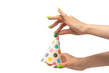 Beyaz arka planda izole edilmiş kadınların ellerinde renkli bir doğum günü şapkası.