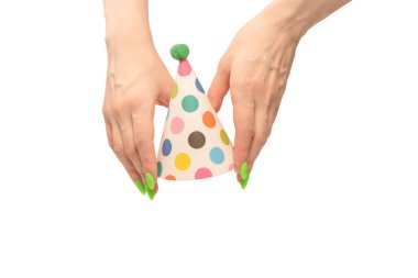 Beyaz arka planda izole edilmiş kadınların ellerinde renkli bir doğum günü şapkası.