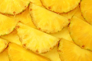Arka plan olarak ananas sulu sarı dilimler. Üst görünüm.