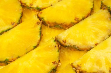 Arka plan olarak ananas sulu sarı dilimler. Üst görünüm.