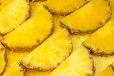 Arka plan olarak ananas sulu sarı dilimler. Üst görünüm.