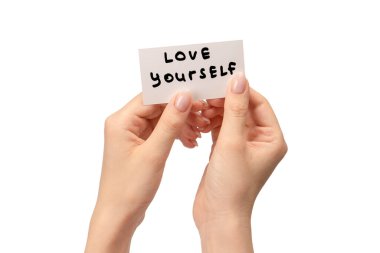 Beyaz bir arka planda el ele izole edilmiş bir kadın kartında kendini sev..