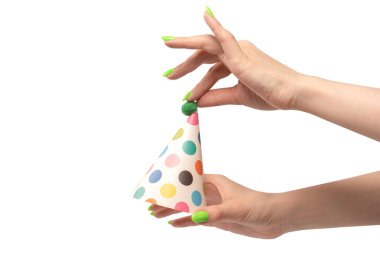 Beyaz arka planda izole edilmiş kadınların ellerinde renkli bir doğum günü şapkası.