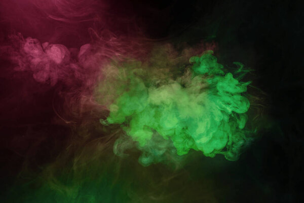 Green and pink steam on a black background. Copy space.