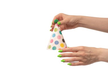 Beyaz arka planda izole edilmiş kadınların ellerinde renkli bir doğum günü şapkası.