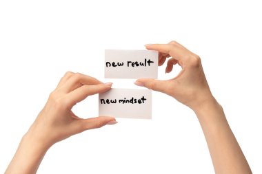 Yeni zihniyet - beyaz arka planda izole edilmiş bir kadının elindeki bir karttaki yeni sonuç metni.  