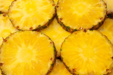 Arka plan olarak ananas sulu sarı dilimler. Üst görünüm.