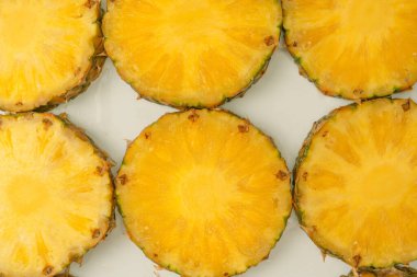 Beyaz arka planda ananas sulu sarı dilimler. Üst görünüm.