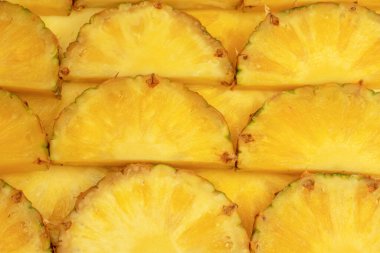 Arka plan olarak ananas sulu sarı dilimler. Üst görünüm.