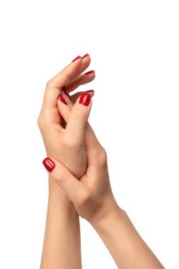 Beyaz arka planda kırmızı tırnaklı kadın elleri var. Kırmızı oje. Kare çivi formu. 