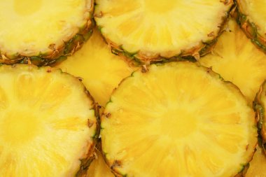 Arka plan olarak ananas sulu sarı dilimler. Üst görünüm.