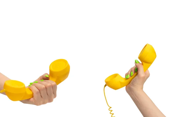 Stock image Yellow handset in woman hand with green nails isolated on a white background. Copy space.