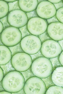 Arka plan olarak taze yeşil salatalık dilimleri. Üst görünüm. 