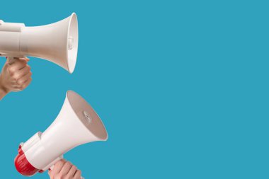 Mavi arka planda kadın eli olan megafon. Boşluğu kopyala. 