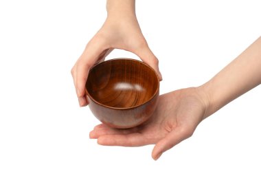 Kadın eli beyaz arka planda izole edilmiş ahşap bir kase tutuyor.. 