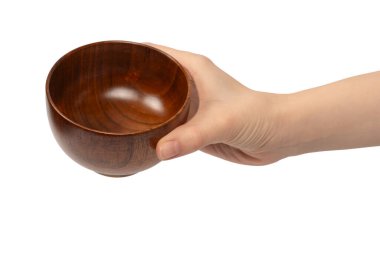 Kadın eli beyaz arka planda izole edilmiş ahşap bir kase tutuyor.. 