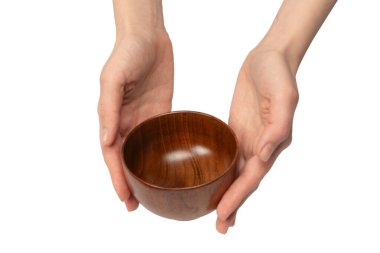 Kadın eli beyaz arka planda izole edilmiş ahşap bir kase tutuyor.. 