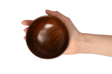 Kadın eli beyaz arka planda izole edilmiş ahşap bir kase tutuyor.. 