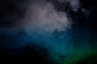 Siyah arka planda mavi ve yeşil buhar. Boşluğu kopyala.