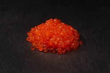 Siyah arka planda kırmızı alabalık havyarı. Üst görünüm.