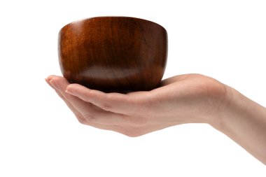 Kadın eli beyaz arka planda izole edilmiş ahşap bir kase tutuyor.. 