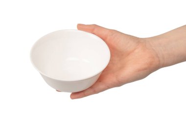 Kadın eli beyaz bir arka planda izole edilmiş seramik bir kase tutuyor.. 