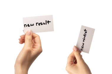 Yeni zihniyet - beyaz arka planda izole edilmiş bir kadının elindeki bir karttaki yeni sonuç metni.  
