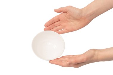 Kadın eli beyaz bir arka planda izole edilmiş seramik bir kase tutuyor.. 