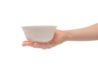 Kadın eli beyaz bir arka planda izole edilmiş seramik bir kase tutuyor.. 