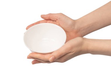 Kadın eli beyaz bir arka planda izole edilmiş seramik bir kase tutuyor.. 