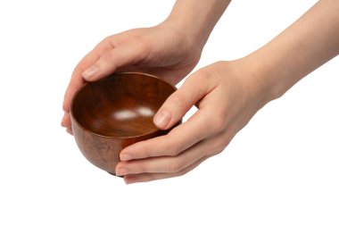 Kadın eli beyaz arka planda izole edilmiş ahşap bir kase tutuyor.. 