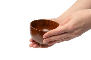 Kadın eli beyaz arka planda izole edilmiş ahşap bir kase tutuyor.. 