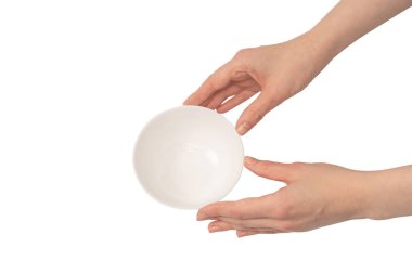 Kadın eli beyaz bir arka planda izole edilmiş seramik bir kase tutuyor.. 