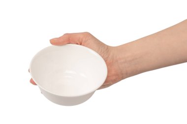 Kadın eli beyaz bir arka planda izole edilmiş seramik bir kase tutuyor.. 