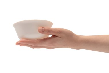 Kadın eli beyaz bir arka planda izole edilmiş seramik bir kase tutuyor.. 