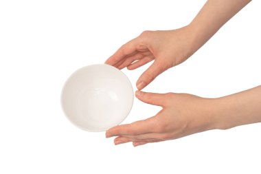 Kadın eli beyaz bir arka planda izole edilmiş seramik bir kase tutuyor.. 