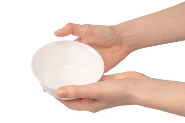 Kadın eli beyaz bir arka planda izole edilmiş seramik bir kase tutuyor.. 