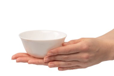 Kadın eli beyaz bir arka planda izole edilmiş seramik bir kase tutuyor.. 