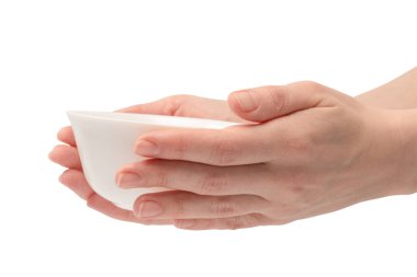 Kadın eli beyaz bir arka planda izole edilmiş seramik bir kase tutuyor.. 