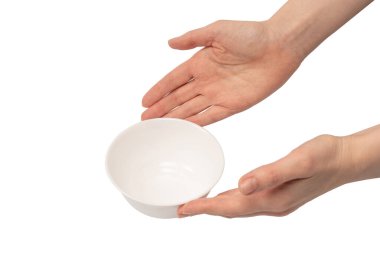 Kadın eli beyaz bir arka planda izole edilmiş seramik bir kase tutuyor.. 