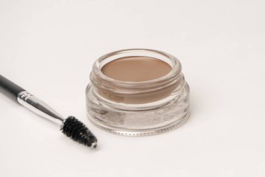 A brow pomade in blonde shade with brush isolated on a white background. Make up. 