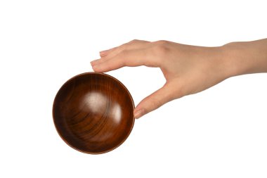 Kadın eli beyaz arka planda izole edilmiş ahşap bir kase tutuyor.. 