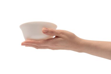 Kadın eli beyaz bir arka planda izole edilmiş seramik bir kase tutuyor.. 