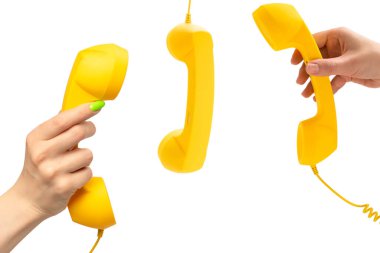 Beyaz arka planda izole edilmiş yeşil tırnaklı kadın eli sarı cep telefonu. Boşluğu kopyala.