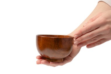 Kadın eli beyaz arka planda izole edilmiş ahşap bir kase tutuyor.. 