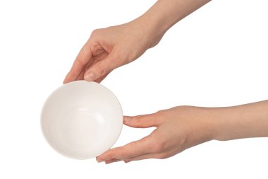 Kadın eli beyaz bir arka planda izole edilmiş seramik bir kase tutuyor.. 