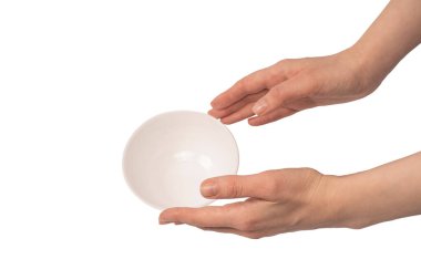 Kadın eli beyaz bir arka planda izole edilmiş seramik bir kase tutuyor.. 