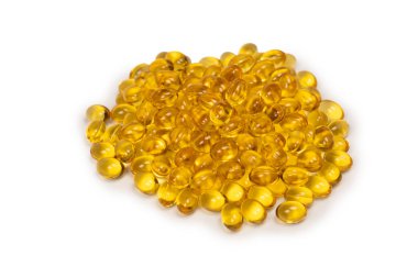 Beyaz zemin üzerinde izole edilmiş bir grup sarı kapsül. 